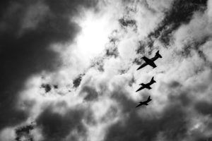 Photo of dark cloudy skies with three jet airplanes flying in formation.