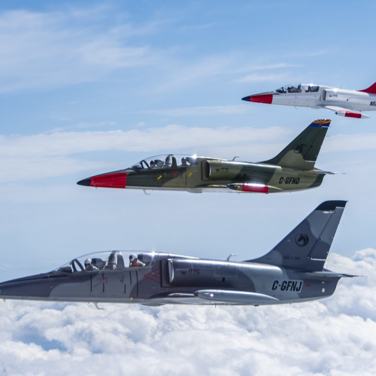 formation training of L-39s Photo of three L-39 Aircraft flying in formation with clouds and blue sky.