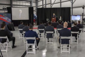 Photo of Giorgio Clementi speaking to student graduates and ITPS staff on a stage with podium.