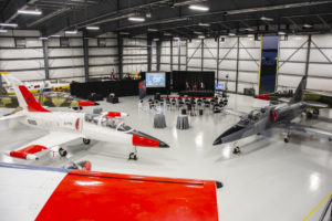 Overhead view in an aircraft hangar of chairs and a stage for a graduation ceremony.
