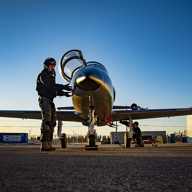 itps20213200039 Photo of pilot and L-39 aircraft with sunset reflecting off the aircraft.