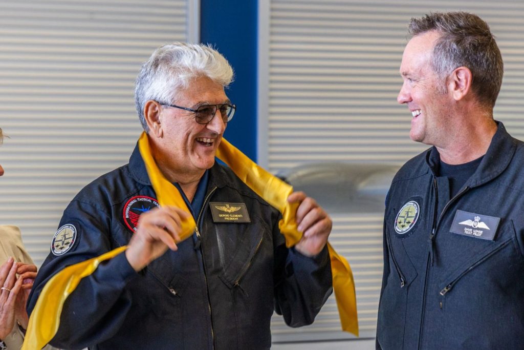 2 Giorgio Clementi holding the grand opening cut ribbon around his neck, while he and Dave smile